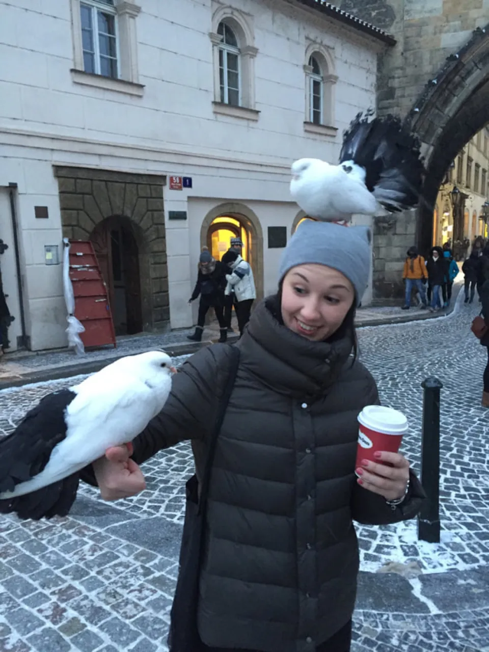 Ksenia mit weißen Tauben in einer winterlichen Straße